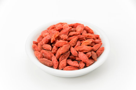 Dried goji berries on a plate on white backgroundの写真素材
