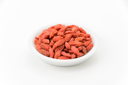 Dried goji berries on a plate on white backgroundの写真素材