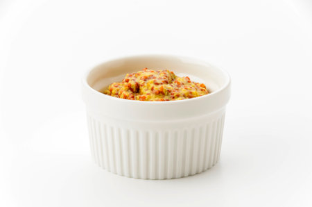 whole grain mustard in cocotte on white backgroundの写真素材