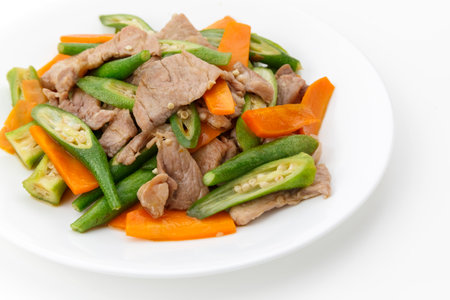 stir-fried vegetables with pork on white plate isolated on white backgroundの写真素材