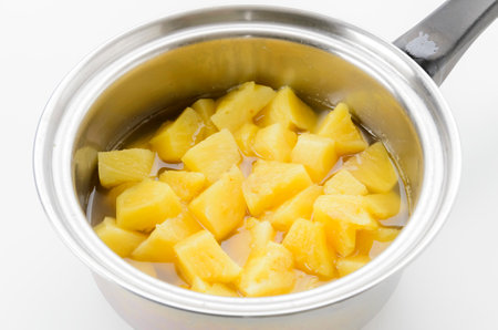 Saucepan with chopped mango isolated on a white background.の写真素材