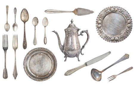 Vintage silver forks, spoons, knives, kettle, plates, ladle and scoop for the cake. Old dishes and cutlery isolated on white background. Rustic. Retro.の写真素材