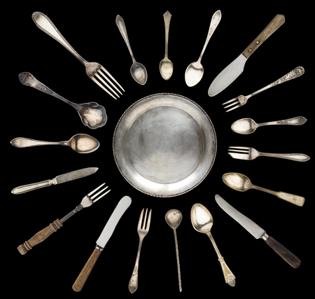vintage spoons, knives, forks and a plate lined with sun isolated on a white backgroundの写真素材