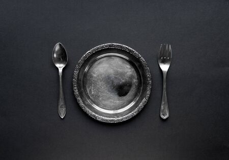Plate, knife and fork on a blackの写真素材