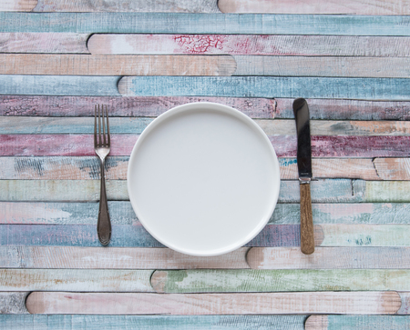 White plates and vintage spoons and fork on color wooden background.
の写真素材