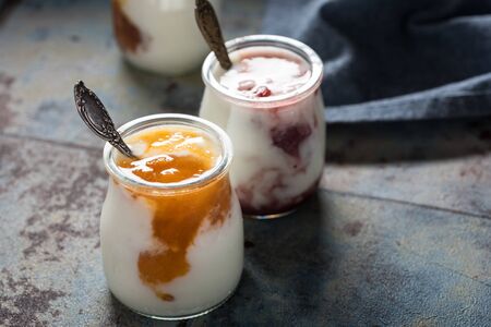 Three portions of fresh natural homemade organic yogurt in a glass jar on a vintage backgroundの写真素材