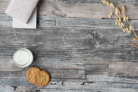 wooden table background, milk, cookies, oats, notebooks. Copy spaceの写真素材