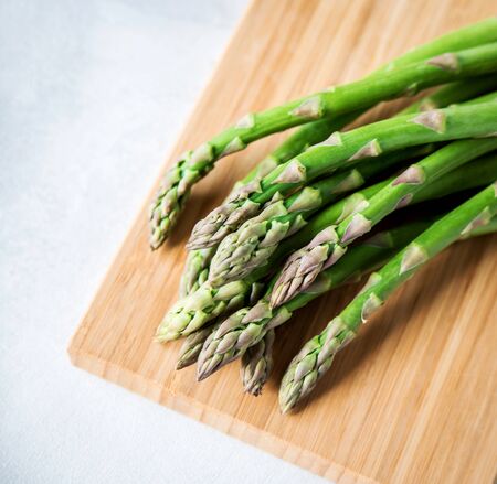 Green fresh asparagus on a wooden board on a white background. Copy space.
の写真素材