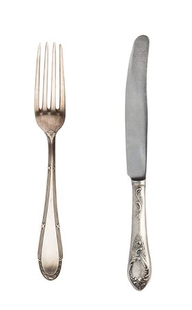 Beautiful old vintage fork and knife isolated on white background. Top view. Retro silverware.の写真素材