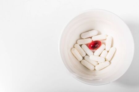 Pills on a white plate. The knife and fork gesture did not like the dish, on a plate with pills.  A pile of multi-colored tablets disguised as food on a plate with cutlery. Medicines on a white plate.の写真素材