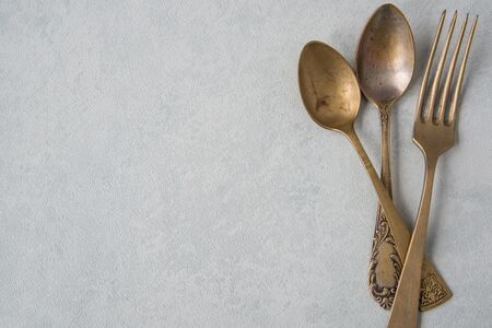 Table setting in vintage style. Antique fork, knife, spoon on old light  background. Space for text,...