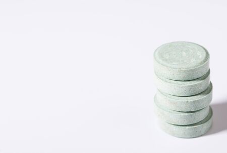 Pill on a white plate. A pile of multi-colored tablets disguised as food on a plate with cutlery on a white plate. Isolated on white background.の写真素材
