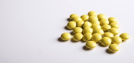 Yellow Pills on a white plate. Isolated on white background. Copy space