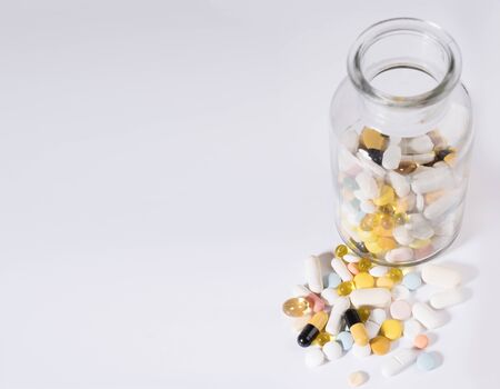 Pills spilled out of pill bottle, top view. Medication and medicine tablets. Copy space.