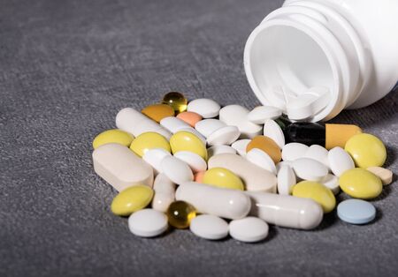 Pills spilled out of pill bottle, top view. Medication and medicine tablets. Copy space.の写真素材