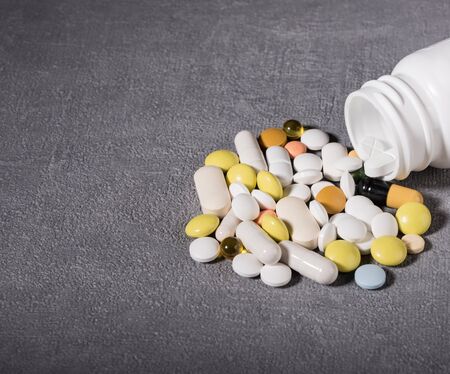 Pills spilled out of pill bottle, top view. Medication and medicine tablets. Copy space.