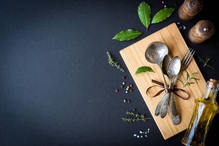 Background for the menu. Wooden board, antique cutlery and condiments.の写真素材