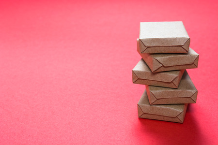 Stack of five wrapped craft boxes on red background with copy spaceの写真素材