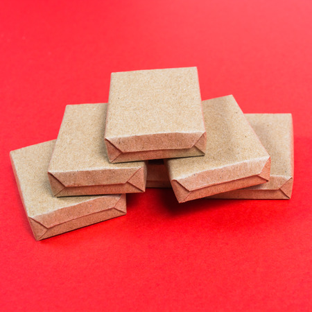 Sixes boxes in craft paper on red background with copy spaceの写真素材