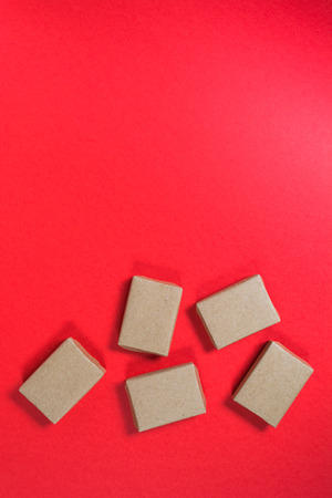 Boxes in craft paper on red background with copy space, top viewの写真素材