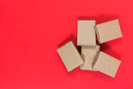 Boxes in craft paper on red background with copy space, top viewの写真素材