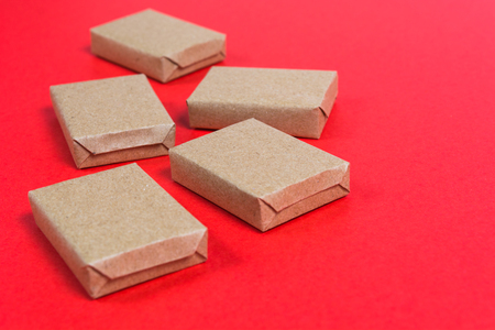 Boxes in craft paper on red background with copy spaceの写真素材