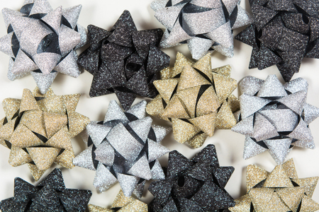 Silver, golden and black holiday bows on white background with copy spaceの写真素材