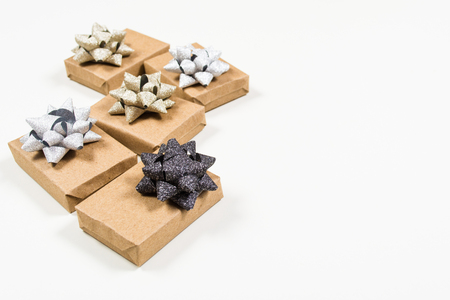 Holiday wrapped gifts packing craft paper with holiday bows on white background with copy spaceの写真素材