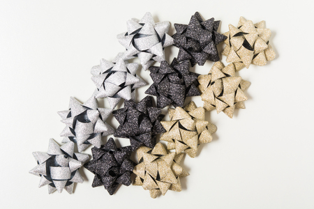 Silver, golden and black holiday bows on white background with copy spaceの写真素材