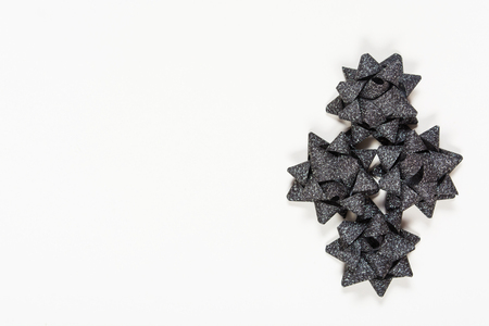 Black shining holiday bows on white background with copy spaceの写真素材
