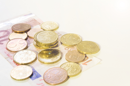 Cash with coins and currency on white background with toned shotの写真素材