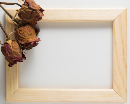 Three red roses with wooden frame on the white background. Copy spaceの写真素材