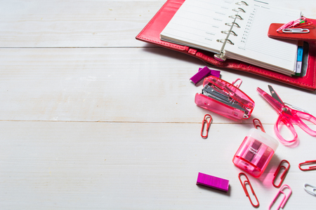 Planning concept for girl or woman with red organizer and pink stationary on the white wooden tableの写真素材