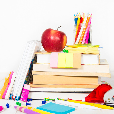Back to school concept - many school stationary and apple on the white wooden tableの写真素材