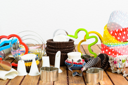Different baking accessories over brown wooden table and white backgroundの写真素材
