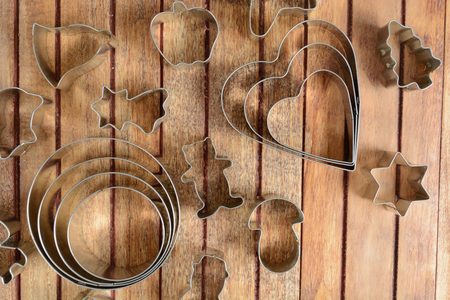 Metal baking cutters over brown wooden backgroundの写真素材