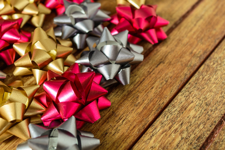 Bows for gifts of three colors over wooden tableの写真素材