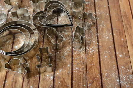 Different cutters for baking with flouring over brown wooden background with copy spaceの写真素材