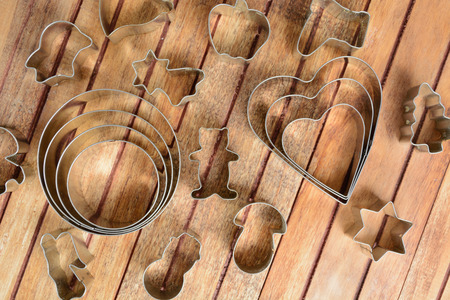 Metal baking cutters over brown wooden backgroundの写真素材