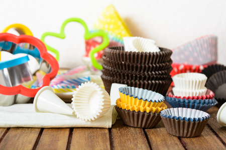 Different baking accessories over brown wooden table and white backgroundの写真素材
