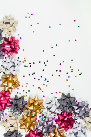 Holiday bows with confetti on white backgroundの写真素材