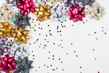 Christmas bows with confetti on white backgroundの写真素材