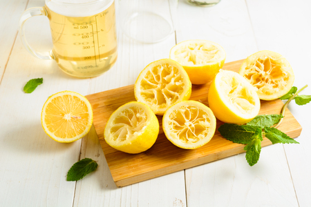 Squeezed lemons, syrup and mint on white backgroundの写真素材