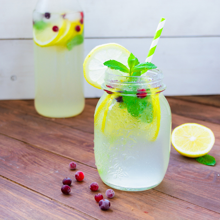 Homemade lemonade decorated with mint over brown wooden background, square shotの写真素材