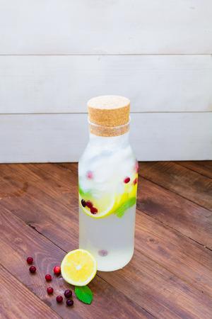 A bottle with detox lemon mint ice water on wooden backgroundの写真素材