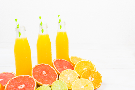 Citrus lemonade in three bottles on white background with copy spaceの写真素材