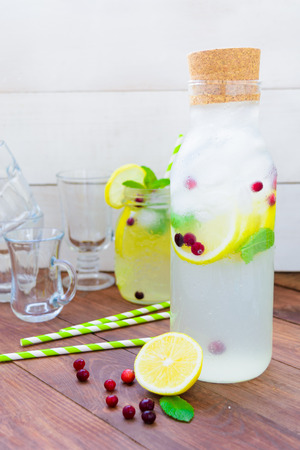 Detox water with lemons mint and ice ready to drink on wooden backgroundの写真素材
