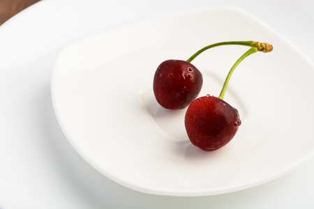 Red cherry on white plates, closeupの写真素材
