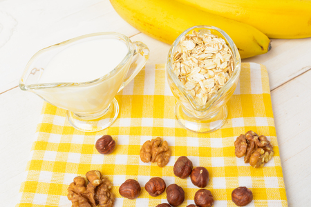 Oatmeal with milk like ingredients on white wooden table and yellow tissueの写真素材