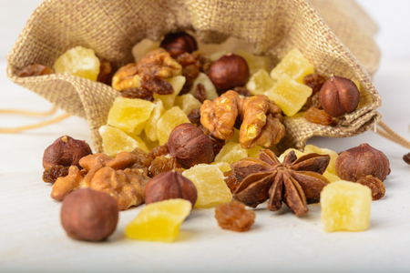 Macro of dried fruits and nuts in material package over white wooden backgroundの写真素材